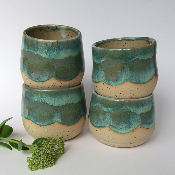 Vier Becher gestapelt mit Glasur in türkis und grün